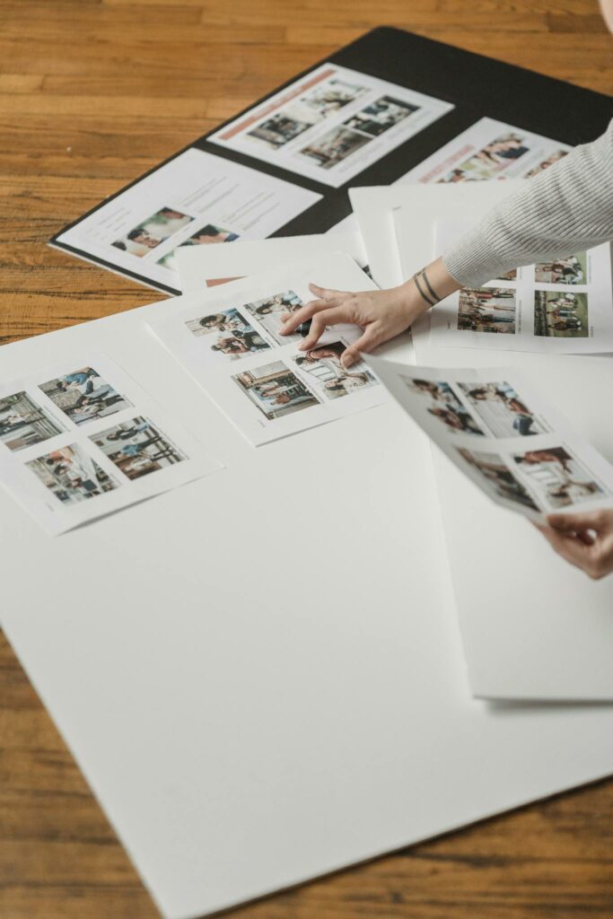 Creative arrangement of printed photos on a wooden floor, showcasing a photography project.